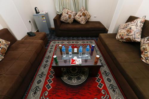 a living room with two couches and a table with drinks at Giza Pyramids Inn in Cairo