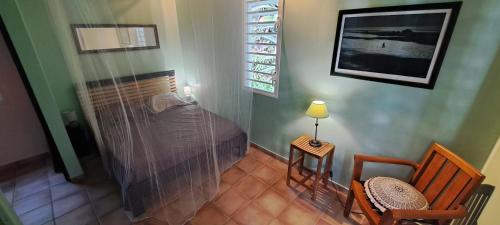 une chambre avec un lit, une table et des chaises dans l'établissement Secret Garden, à Pointe-Noire