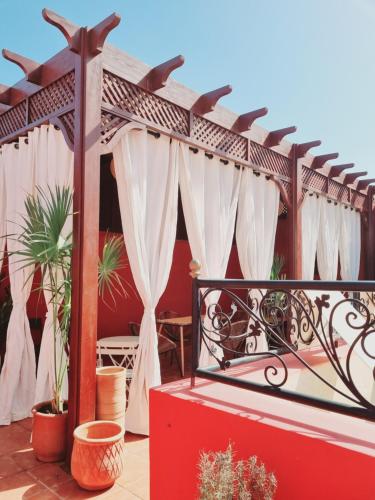 a pergola with white curtains on a patio at Labigarade riad in Marrakesh