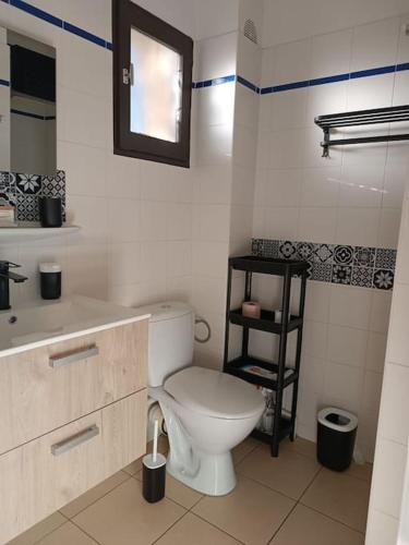 une salle de bain blanche avec des toilettes et un lavabo dans l'établissement studio rénové dans résidence de vacances avec grande piscine chauffée, parking et terrasse, au Cap d'Agde