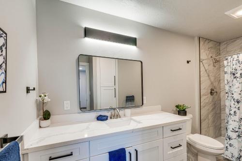 a white bathroom with a sink and a mirror at Convenient Great Falls Condo Less Than 1 Mi to Shops! in Great Falls