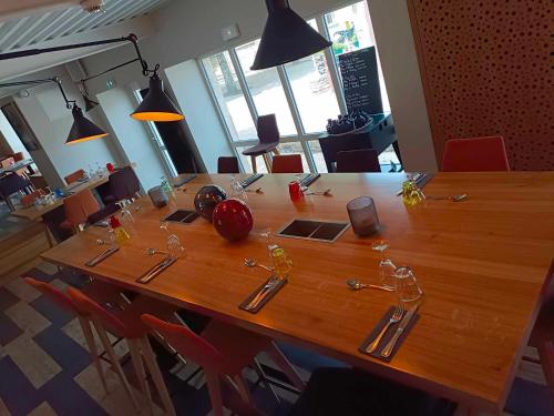 a large wooden table with utensils on it at Logis Hostellerie de l'Abbaye in Celles-sur-Belle