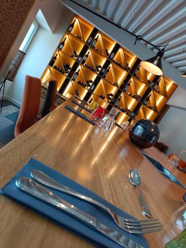 a wooden table with silverware on top of it at Logis Hostellerie de l'Abbaye in Celles-sur-Belle
