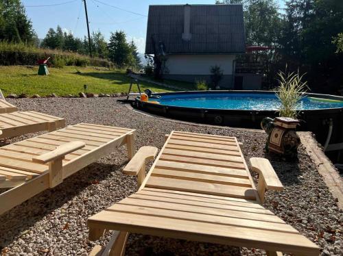 - deux bancs en bois en face d'une piscine dans l'établissement Forest Home, à Pale