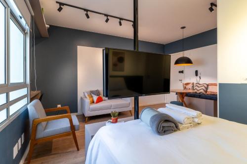 a bedroom with a large screen tv and a bed at BSB STAY - Estúdios - LONG STAY in Brasilia