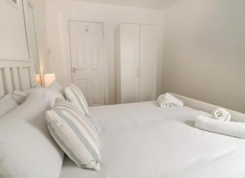 uma cama branca com duas almofadas em Sandown - 2 minutes walk to the Downs, Restaurants Bars & Beaches em Torquay