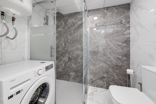 a bathroom with a washing machine and a shower at Modern Apartment Bergantin in Torrevieja