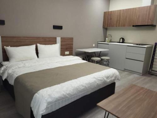 a bedroom with a large bed and a kitchen at Crystal Wood Apartment 213 in Bakuriani