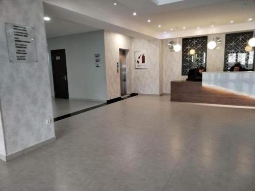 an empty lobby with a person sitting at a counter at Crystal Wood Apartment 213 in Bakuriani