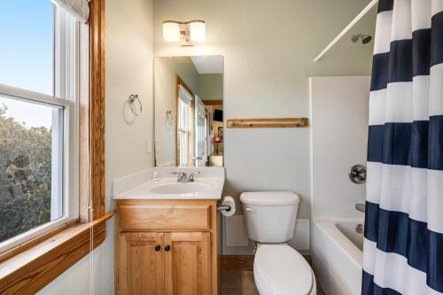 a bathroom with a sink and a toilet and a window at Blue Waters #18-22 in Avon