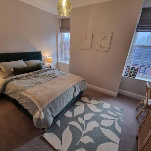a bedroom with a large bed and a rug at Apartment 20 min walk from Manchester City Centre in Manchester