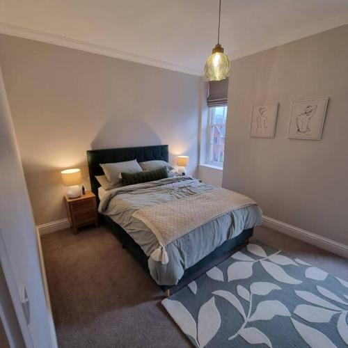 a bedroom with a bed and two lamps and a window at Apartment 20 min walk from Manchester City Centre in Manchester
