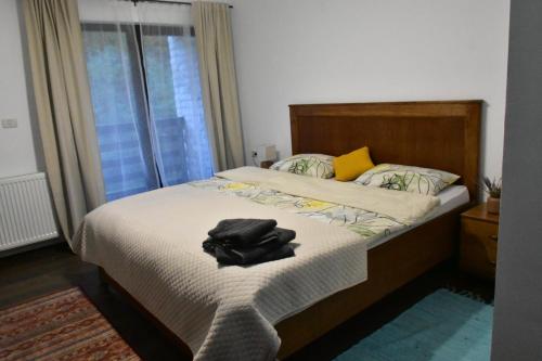 a bedroom with a bed with a black shirt on it at Pensiunea Crenguța Fermecată in Cladova