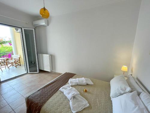1 dormitorio con cama con almohadas y balcón en Antonello House, en Lixouri