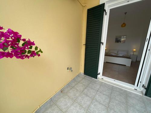 una habitación con una puerta con flores púrpuras en la pared en Antonello House, en Lixouri