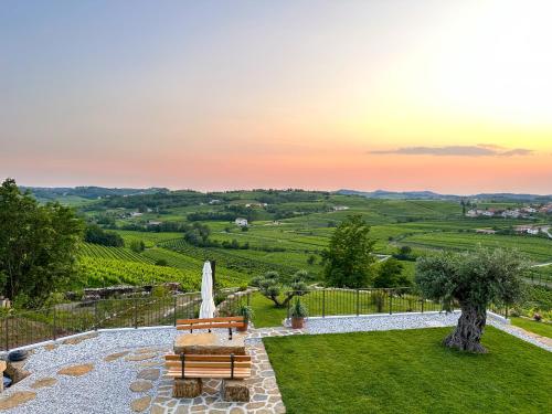 a garden with a bench and a umbrella at A Luxury 100m2 Apartment in a Chic Vineyard Villa - Ca' S. Lorenz in Dobrovo