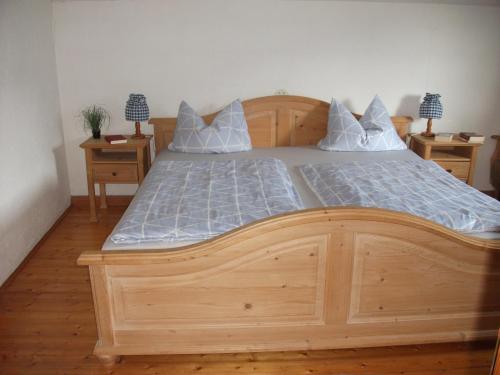 a wooden bed in a bedroom with two night stands at Schneiderhof Ferienwohnung mit Alpenblick in Fischbachau