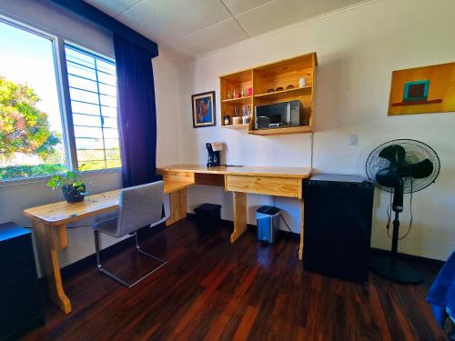 an office with a wooden desk and a fan at Casa Jardin del Mango in San José