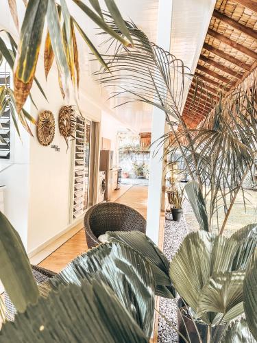 a living room with palm trees and chairs at Vaikea Fare in Mahina