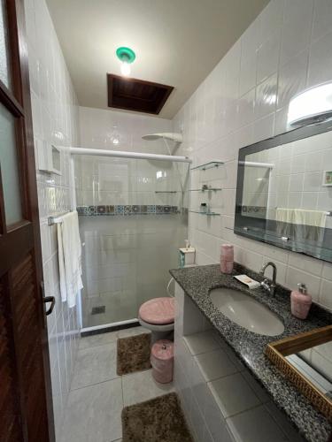 a bathroom with a sink and a glass shower at Casa em Praia Seca, Araruama. in Araruama