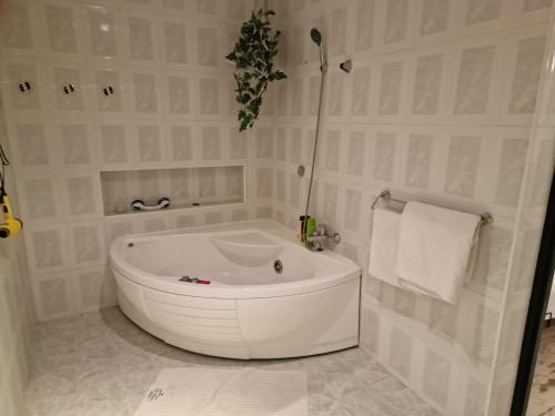a white bath tub in a white bathroom with towels at Agroturystyka Gramburg in Zblewo