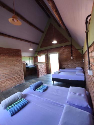 una camera con tre letti in una stanza con di Pousada do Chicó a São Roque de Minas
