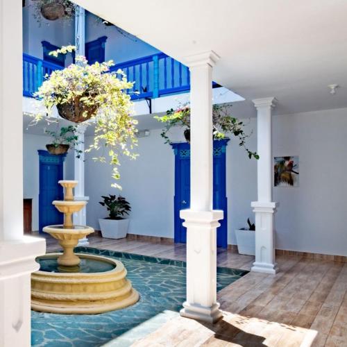 a lobby with a fountain and blue walls at Finca Hotel Monte Carlos in Santa Bárbara