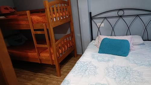 a bedroom with a bunk bed with a blue pillow at habitaciones, restaurante asador el puente Galdames in San Pedro de Galdames