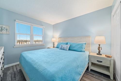 Un dormitorio con una cama azul y una ventana en Seacrest 507, en Gulf Shores