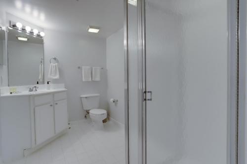 a white bathroom with a shower and a toilet at Quiet Condo in the Heart of Ballston in Arlington