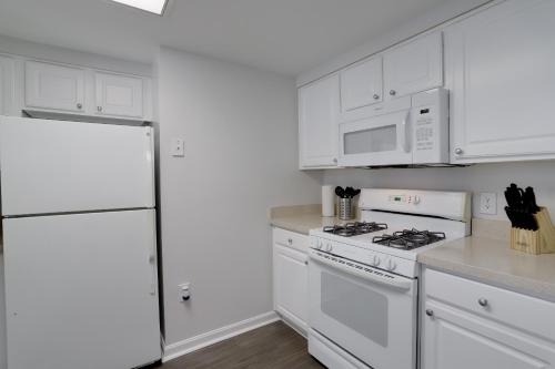a kitchen with white cabinets and a white refrigerator at Quiet Condo in the Heart of Ballston in Arlington