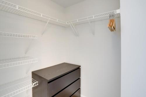 a closet with a black drawer and white shelves at Quiet Condo in the Heart of Ballston in Arlington