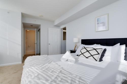 a white bedroom with a large white bed with white pillows at Quiet Condo in the Heart of Ballston in Arlington