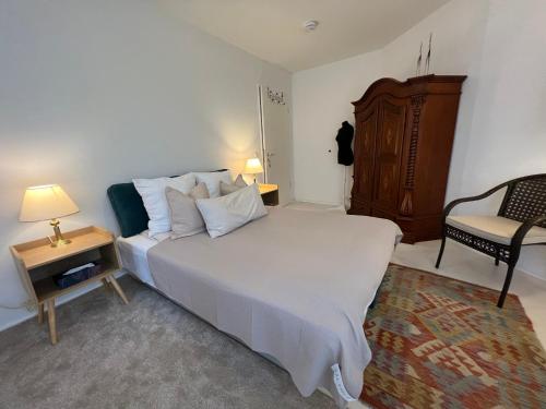 sypialnia z dużym białym łóżkiem i krzesłem w obiekcie Privatzimmer 15 qm w Monachium