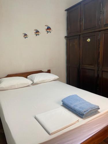 a white bed with a blue towel on it at Sobrado 5 minutos a pé até a Basilíca in Aparecida