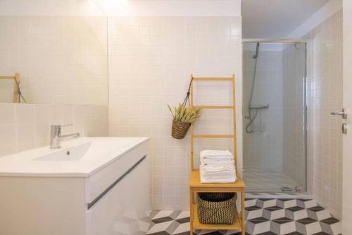 een witte badkamer met een wastafel en een douche bij 157 Flores Apartment in Porto