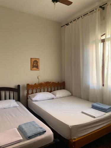 2 aparte bedden in een kamer met een raam bij Sobrado 5 minutos da Basílica in Aparecida