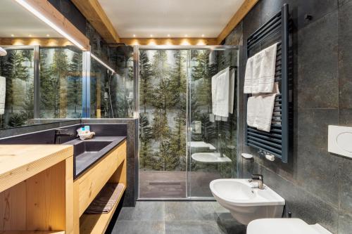 a bathroom with a shower and a toilet and a sink at Hotel Columbia & Spa in Cortina dʼAmpezzo