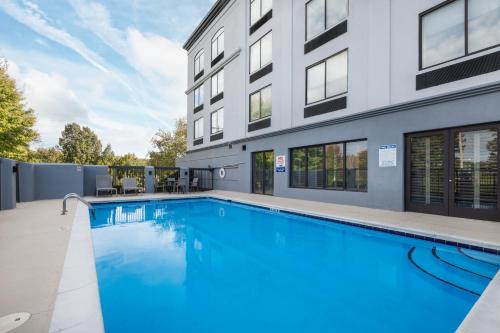 a swimming pool in front of a building at Wingate by Wyndham Charlotte Concord Mills/Speedway in Concord