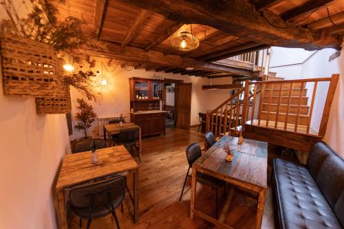 restauracja z drewnianymi stołami i krzesłami oraz pokój w obiekcie Casa Rural Piñeiro, de Vila Sen Vento w mieście O Pedrouzo