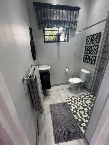 La salle de bains est pourvue de toilettes, d'un lavabo et d'une fenêtre. dans l'établissement RR Luxury apartment, à Welkom