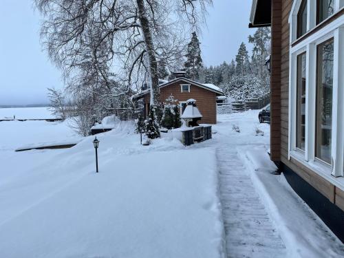 a yard covered in snow next to a house at Villa Joutsen in Hollola