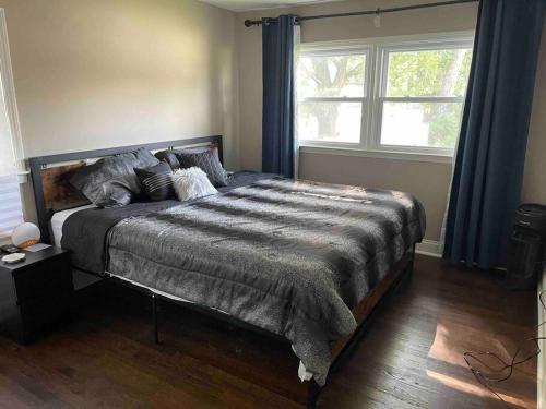 ein großes Bett in einem Schlafzimmer mit Fenster in der Unterkunft Luxury Home Fenced In Yard Palos Heights 3BR/2BA 