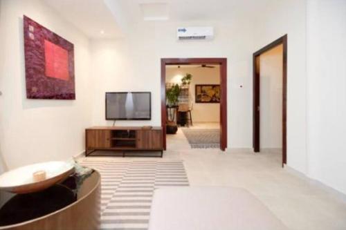 a living room with a flat screen tv on a wall at Stylish 2 Bedroom in Osu in Accra