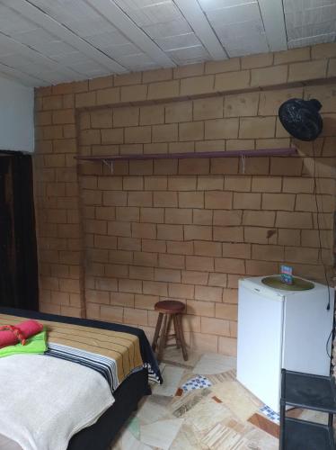 um quarto com uma cama e uma parede de tijolos em Pesque e Sorte Escondidinho em Santana do Riacho
