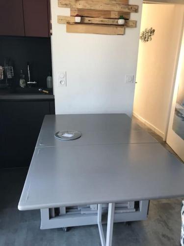 - une table blanche dans une cuisine à côté d'un réfrigérateur dans l'établissement Studio 22m2 classé * calme et accès direct Plage, à Saint-Hilaire-de-Riez