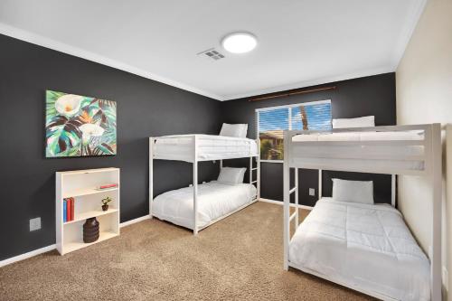 a bedroom with two bunk beds and a window at Seven Palms in Henderson