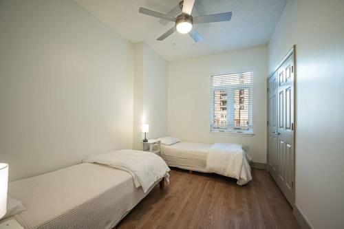 a bedroom with two beds and a ceiling fan at Uptown Charlotte Style in Charlotte