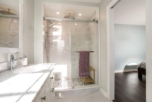 a white bathroom with a shower and a sink at Centrally Located Stylish House in Vaughan