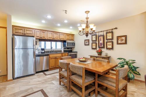 a kitchen with a wooden table and a stainless steel refrigerator at Seven Springs Stoneridge 3 Bedroom Standard Condo, Private Deck condo in Champion